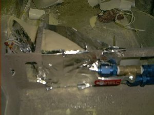 This is the heater pipes and flow control valve seen from the front. The pour foam insulation is forming between the metal duct tape guides.>
<IMG SRC = 